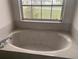 Close-up of a bathtub positioned below a window, ready for relaxation and comfort at 1 Clubhouse Rd, Rotonda West, FL 33947