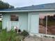 A view of the side of the house shows roofing material and tinted sliding doors from the exterior at 1 Clubhouse Rd, Rotonda West, FL 33947