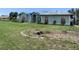Exterior view of a single-story home needing repairs, with a neglected lawn and blue tarp on the roof at 1 Clubhouse Rd, Rotonda West, FL 33947