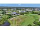 Aerial view of homes with pools near the golf course and pond, showcasing the community layout at 1002 Rotonda Cir, Rotonda West, FL 33947