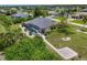 Home with a screened pool, surrounded by lush greenery, set on a large lot with a winding pathway and additional parking at 1002 Rotonda Cir, Rotonda West, FL 33947