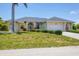 Traditional home with a manicured lawn, arched entryway, white columns, and a spacious driveway leading to an attached garage at 1002 Rotonda Cir, Rotonda West, FL 33947