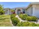 Charming home exterior featuring a well-manicured garden pathway, elegant arched entryway, and classic architectural details at 1002 Rotonda Cir, Rotonda West, FL 33947