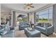 Bright living room with comfortable blue sofas and a view of the pool and golf course at 1002 Rotonda Cir, Rotonda West, FL 33947