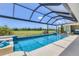 Inviting screened pool area with a clear blue pool, golf course view, and outdoor seating, perfect for relaxation and entertainment at 1002 Rotonda Cir, Rotonda West, FL 33947