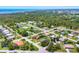 Expansive aerial view showcasing a peaceful residential area surrounded by dense trees and distant water at 1040 Caples St, Englewood, FL 34223