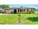 Attractive single-Gathering home boasting a well-kept lawn, mature landscaping, and a welcoming facade at 1040 Caples St, Englewood, FL 34223
