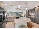 Spacious kitchen features gray cabinets, a large countertop island, pendant lighting, and modern appliances at 1040 Caples St, Englewood, FL 34223