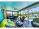 Relaxing screened-in patio with comfortable seating, ceiling fan, and backyard pool at 1040 Caples St, Englewood, FL 34223