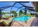 A screened-in pool with brick patio and lounge chairs offers a relaxing outdoor space at 1040 Caples St, Englewood, FL 34223