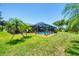 Screened pool with surrounding yard, landscaping, and partial home view at 1040 Caples St, Englewood, FL 34223