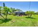 The enclosed pool sits within a lawn and has landscaping at 1040 Caples St, Englewood, FL 34223