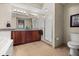 Bathroom with dual sinks, granite countertops, a walk-in shower, and ample lighting at 10521 Amberjack Way # 303, Englewood, FL 34224