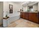 Bathroom featuring dual sinks, granite countertops, and a soaking tub at 10521 Amberjack Way # 303, Englewood, FL 34224