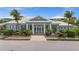 Exterior of the community clubhouse with lush tropical landscaping, sidewalk, and an inviting entrance at 10521 Amberjack Way # 303, Englewood, FL 34224