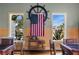 Bright game room decorated in nautical theme with American flag and wicker bar cart between windows at 10521 Amberjack Way # 303, Englewood, FL 34224