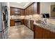 Modern kitchen with stainless steel appliances, wood cabinets, granite countertops, and tile backsplash at 10521 Amberjack Way # 303, Englewood, FL 34224