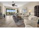 Bright living room with tile floors, ceiling fan, comfortable seating, and a sliding glass door to a balcony at 10521 Amberjack Way # 303, Englewood, FL 34224