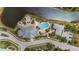 Aerial view of a community pool and recreational facilities surrounded by lush landscaping and serene water features at 10521 Amberjack Way # 303, Englewood, FL 34224