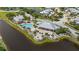 Aerial view showcasing the community pool and amenities area nestled along a lake, with multiple buildings at 10521 Amberjack Way # 303, Englewood, FL 34224