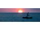 Beautiful sunset over the water with a boat silhouetted against the colorful sky at 10521 Amberjack Way # 303, Englewood, FL 34224