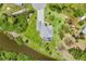 A serene aerial view showcasing the home with a drive, surrounded by lush greenery and a tranquil body of water at 124 Cutlass Dr, Rotonda West, FL 33947