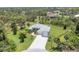 Stunning aerial view of a gray home with a water view, manicured lawn, and spacious driveway at 124 Cutlass Dr, Rotonda West, FL 33947