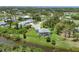 An elevated aerial view of a lovely home with an enclosed pool, lush yard, and tranquil water views at 124 Cutlass Dr, Rotonda West, FL 33947