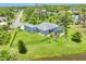 Aerial view of a home showcasing a beautiful backyard, pool, well-manicured lawn, and a fence at 124 Cutlass Dr, Rotonda West, FL 33947