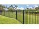 A beautiful backyard view showing a black metal fence, green grass, and a view of the water at 124 Cutlass Dr, Rotonda West, FL 33947