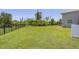 A large backyard with lush green grass and a fence offers plenty of space for outdoor activities at 124 Cutlass Dr, Rotonda West, FL 33947