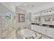 Elegant bathroom with soaking tub, marble tiling, dual vanity sinks and natural light at 124 Cutlass Dr, Rotonda West, FL 33947