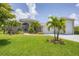 Beautiful gray home featuring tropical landscaping, a paver driveway, and an attached garage at 124 Cutlass Dr, Rotonda West, FL 33947