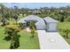 Charming gray home with manicured lawn, tile roof and decorative driveway in a lush, green neighborhood at 124 Cutlass Dr, Rotonda West, FL 33947
