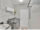 This laundry room has a washer and dryer, storage shelves, and access to an exterior door at 124 Cutlass Dr, Rotonda West, FL 33947