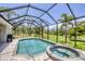 This stunning screened-in pool includes a hot tub and views of the water and natural Florida landscape at 124 Cutlass Dr, Rotonda West, FL 33947