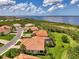 Aerial shot of homes near the water featuring tile roofs, manicured lawns and lush tropical landscaping at 13051 Creekside Ln, Port Charlotte, FL 33953