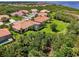 Aerial shot displays houses surrounded by mature trees, lush lawns, and a screened in pool at 13051 Creekside Ln, Port Charlotte, FL 33953
