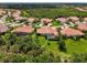 Beautiful aerial view of the community featuring lush landscaping, tile roofs, and serene surroundings at 13051 Creekside Ln, Port Charlotte, FL 33953