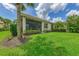 Beautiful backyard with an outdoor living space, manicured lawn, and vibrant landscaping surrounding the home at 13051 Creekside Ln, Port Charlotte, FL 33953