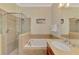 Bright bathroom featuring a walk-in shower, large soaking tub, vanity and stylish tile work at 13051 Creekside Ln, Port Charlotte, FL 33953