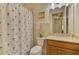 Cozy bathroom featuring a decorative shower curtain and a vanity with a neutral-toned countertop at 13051 Creekside Ln, Port Charlotte, FL 33953