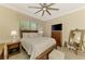 Well-lit bedroom featuring a large bed, a TV, a dresser, and a ceiling fan at 13051 Creekside Ln, Port Charlotte, FL 33953