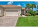 Home exterior with well-manicured lawn and landscaping leading to an attached two-car garage at 13051 Creekside Ln, Port Charlotte, FL 33953