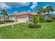 Charming single-story home with tile roof, attached garage, and lush tropical landscaping at 13051 Creekside Ln, Port Charlotte, FL 33953