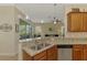Granite countertops with stainless dishwasher, tile backsplash, and view from kitchen to living room at 13051 Creekside Ln, Port Charlotte, FL 33953