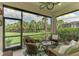 Relaxing screened-in lanai with comfortable wicker furniture and lush green views of the backyard at 13051 Creekside Ln, Port Charlotte, FL 33953