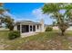 Inviting backyard featuring a screened-in lanai and lush landscaping, perfect for outdoor relaxation and entertaining at 1337 Le Pera Rd, Englewood, FL 34223