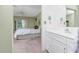 Bedroom leading into bathroom featuring a ceiling fan and sliding glass door at 1337 Le Pera Rd, Englewood, FL 34223