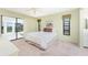 Cozy bedroom with white comforter, neutral walls, and sliding door access at 1337 Le Pera Rd, Englewood, FL 34223